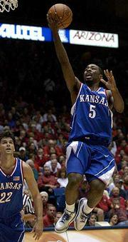 Left-hander Keith Langford scores a right-handed layup at Arizona.
Some TV announcers have criticized the KU freshman for not being
able to go to his right.