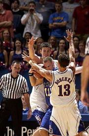 Kansas' Jeff Boschee (13) and Nick Collison sandwich UMKC's Matt
Suther. The Jayhawks held on to beat the 'Roos, 79-68, on Saturday
night at Allen Fieldhouse.
