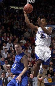 The jayhawks' Michael Lee, right, goes for a layup as UMKC's Matt
Suther tries to get out of the way.