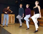 With fiddle music provided by Dan Grotewohl, student Jeff Potter,
second from left, and Christine Scott, right, rehearse an Irish
step dance with instructor-choreographer Jean Denney in Robinson
Center at Kansas University.