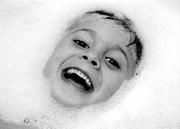 Natural light was used to take this black-and-white picture of a
child's face surrounded by bubbles in a bathtub. For indoor natural
light photographs, make the room as bright as possible.