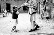 A young student at the refugee school for the sciences along the
Afghanistan-Pakistan border, finished with his exam, wonders aloud
how he did to a faculty member.
