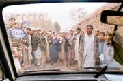 A group of Afghan students at the United Nations-sponsored Eagle
Eye School for the Sciences for Displaced Afghan Youth crowd around
as Smith's vehicle backs away from the school grounds.