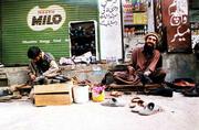 A man proud of his resemblance to Osama bin Laden shines shoes at
Aabpara Market in Islamabad, Pakistan, more than a week before his
terrorist double was last detected alive at the Tora Bora cave
complex, alive and possibly fleeing toward Pakistan.