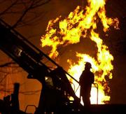 A Hutchinson firefighter watches from atop a ladder truck as a
natural gas leak burns inside a downtown Hutchinson building. Still
puzzled about the exact cause of the migration of underground
gasses that fueled the fires, Kansas University geologists have
applied for a $4 million grant from the U.S. Department of Energy
to study the issue. The Kansas Geological Survey, based at KU, has
spent $150,000 on the investigation since the fires of Jan. 17 and
18, 2001.