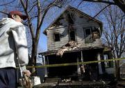 Derek Hein, One of four residents who escaped an early-morning
house fire on Ohio Street, surveys the damage to his rental house.
Hein, who injured his ankle jumping from a second-floor awning, was
awakened to the Friday fire by his barking dog, Aiko, who died in
the fire.