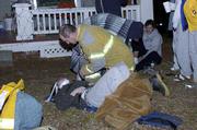 A Lawrence-Douglas County firefighter tends to a victim of an
early-morning fire at 1216 Ohio. Three residents had to jump from
the house to escape the fire Friday.