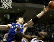Ku's Nick Collison (4) stretches to grab a rebound as Texas
A&M's Keith Bean looks on. The Jayhawks beat the Aggies, 86-74,
on Saturday in College Station, Texas.