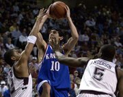 Kansas' Kirk Hinrich (10) shoots between Bernard King, left, and
Nick Anderson. Hinrich finished with 15 points.