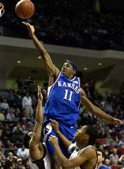 Ku's Aaron miles (11) glides in for two of his 10 points against
Bradley Jackson, left, and Bernard King.