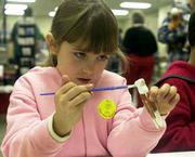 McKenzie Edmonds, 6, Lawrence, paints the finishing touches on a
clothespin soon to be transformed into the body of a bald eagle
with the addition of wings and a beak. The Clinton/Perry Lake Corps
of Engineers sponsored the crafts exhibit at the 2002 Kaw Valley
Eagles Day activities Sunday afternoon at the Douglas County 4-H
Fairgrounds.