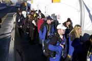People wait in the cold to gain access to the Media Center Friday
in Salt Lake City. The security checks have caused queues to form
outside the Media Center due to their stringency. The Salt Lake
City Winter Olympic Games and their 375.5 hours of TV coverage
begin Friday.