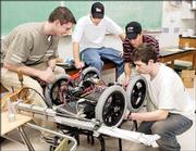 Lawrence High School students work to get their robot ready for
shipment next week to a robot competition in St. Louis. Working
Thursday night were, from left, senior Matt Whitehead, junior
Kelsey Mullis, senior Camron Flanders and senior Ted Alsop.