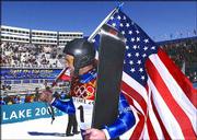 SNOWBOARDER Chris Klug carries the American flag after winning the
bronze medal in the giant slalom. Klug's third-place finish Friday
in Salt Lake City brought the U.S. medal count for the Games to 14.