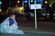 Eight-year-old Jerry Ratcliff watches the activity of firefighters
as they work in teams to extinguish the flames in an apartment
building near 24th and Missouri streets. One resident of the Coach
Light Apartments, Janet Murphy, died in the fire. More than 20
people who lived in the building were left without a home.