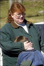 Lisa Cash clutches her son, Richard Cash, as she talks about
identifying her mother's body after it was recovered from the
Tri-State Crematory. Investigators on Monday unearthed dozens more
corpses scattered around a northwest Georgia crematory. The count
rose to 139.