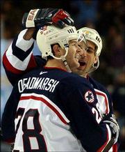 Adam Deadmarsh (28) and Chris Chelios celebrate a third-period
goal. Their U.S. hockey team hammered Belarus, 8-1, on Monday in
Kearns, Utah.