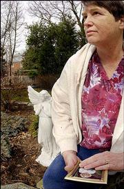 Peggy Neff holds a photo of her partner, Sheila Hein, in the garden
of their house. Hein, an Army budget and management specialist and
Neff's partner of almost 18 years, was killed in the Sept. 11
terrorist attack on the Pentagon. Neff shared her thoughts and
memories Friday at their residence in Hyattsville, Md.