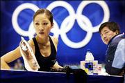 U.S. figure skater michelle kwan stretches while her father, Danny,
watches during Wednesday's practice. Kwan will skate for a gold
medal tonight.