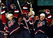 Members of the United States hockey team celebrate a first period
goal by their teammate Bill Guerin during Team USA's semifinal
match with Russia. The Americans defeated Russia 3-2 Friday to
advance to the gold medal game against Canada.
