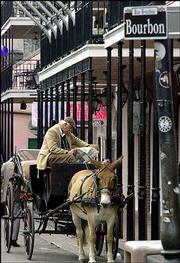 Rick Leiby reads a paper as he waits for a fare on Bourbon Street
in the French Quarter of New Orleans. The street is named for
French kings, not whiskey.