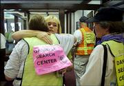 Brenda van Dam, facing the camera, hugs volunteers at a search
center in San Diego and thanks them for helping to search for her
7-year-old daughter, Danielle. The arrest Friday of David
Westerfield on suspicion of kidnapping Danielle spurred hundreds of
volunteers to show up Saturday at the center to look for clues to
Danielle's whereabouts.