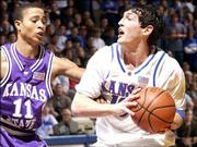 KU's Kirk Hinrich, right, gets past K-State's Larry Reid. Hinrich
had a game-high 24 points in the Jayhawks' 103-68 rout on Wednesday
at Allen Fieldhouse.