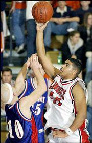 Lawrence High's Brandon McAnderson, right, scores against
Leavenworth's Sam Floetke. McAnderson had 22 points and 12 rebounds
as the Lions defeated Leavenworth, 62-50, in the Class 6A sub-state
semifinals Friday night at Free State High.
