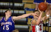 Lawrence High's Jamie Peterson, right, gets off a shot despite the
defense of Leavenworth's Joe Manthe. The Lions beat the Pioneers,
62-50, on Friday at Free State High.