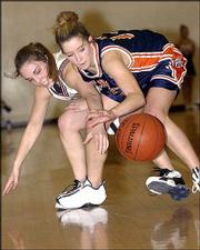 Lawrence high's Leigh Debiasse, left, has the ball knocked away by
Olathe East's Erin Mehi. East won the Class 6A sub-state final,
50-39, Saturday at Olathe North.