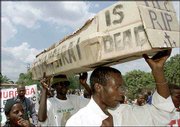 Ruling party Supporters carry a mock coffin while celebrating the
victory of Robert Mugabe in the Zimbabwean presidential election in
Harare. The coffin symbolizes the burial of the main opposition
leader Morgan Tsvangarai. Several countries dimissed the results,
saying the election was marred by violence and intimidation.