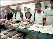Young boys and girls stand in line to receive their lunches at
Jefferson Middle School cafeteria in Long Beach, Calif. One of
every five children who gets free or discounted meals at school may
be ineligible for them because their family income is too high,
according to a government study.