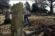 Mitch Young, supervisor at Oak Hill Cemetery, 1605 Oak Hill, tidies
up around the grave of Lucy Hobbs Taylor, the first women to
graduate from dental college who then came to Lawrence to start a
practice.