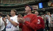 Craig Nash, Atlanta, left, a former Perry resident, and Curt Annis,
Perry, right, applaud the Kansas Jayhawks as they come onto the
court at the Georgia Dome. The pair were at the Atlanta dome on
Friday for an open practice session. The two are still looking for
tickets to today's Kansas-Maryland game.