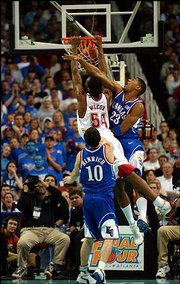 Maryland's Chris Wilcox (54) dunks despite the defense of Wayne
Simien (23). The Terps beat KU, 97-88, in a national semifinal on
Saturday in Atlanta.
