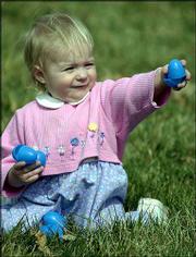 Kaelyn Weiss, 16 months, collects plastic eggs during an Easter egg
hunt at South Park. Eggs were exchanged for candy prizes during
Saturday's outdoor hunt sponsored by Lawrence Parks and Recreation
and Hy-Vee Food Stores.