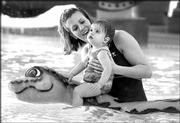 The big water snake is not a threat to little Ashlyn Pope, 13
months, as she plays with her mother, Michelle, at the Lawrence
Indoor Aquatic Center's interactive children's pool. The $9.3
million, 850,000-gallon center at 4706 Overland Drive, adjacent to
Free State High School, opened last summer.