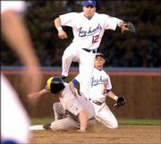 Kansas second basEMAN Travis Metcalf (12) climbs the back of
Wichita State's Drew Moffitt (7) to complete a double play as
Brandon Shepard (2) looks on. The Jayhawks defeated the Shockers,
9-1, Tuesday night at Hoglund Ballpark.