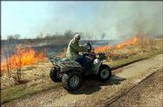 Roger Boyd, a Baker University professor of biology and caretaker
of the Baker Wetlands, watches a fire burn in the wetlands. The
exercise Tuesday was part of an every-other-year rite to rid the
area of trees, shrubs and sunflowers and generate new prairie grass
growth.