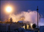 Smoke blankets the Church of the Nativity, center, and a flare
falls over Manger Square compound as heavy gunfire breaks out
during an Israeli military operation in Bethlehem. Palestinians
inside the church have been in a standoff with Israeli troops since
April 2.