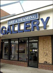 Plywood stands in place of a shattered window at Roy's Gallery,
1410 Kasold Drive. Late Saturday or early Sunday, a thief broke the
gallery window and took a $3,500 sculpture by Lawrence artist Jim
Brothers.