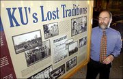 Henry Fortunato, a Kansas University graduate student, is the
project director of a soon to be unveiled extensive Web site on the
history of KU. Fortunato was photographed last week with one of the
large panels that will accompany the project and will be on display
in the Kansas Union.