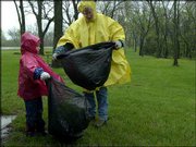 A steady rain doesn't keep members of the Murphy family of Lawrence
from participating in the 19th annual Clinton Lake Cleanup. Hannah
Murphy, 6, and her mother, Mary Murphy, searched for litter
Saturday around a Clinton Lake picnic area.