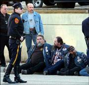 Police stand next to unidentified motorcycle gang members after a
fatal brawl took place at the Hellraiser Ball 2002in Plainview,
N.Y. Conflicts between Hells Angels and rival gangs are on the
increase, law enforcement officials note.