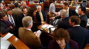 House members gather at the front of the House chamber in Topeka to
sort out how to deal with a tie vote on a bill to allow slot
machines in the state after Rep. Barbara Ballard, center with hand
out, D-Lawrence, said her vote button had malfunctioned causing the
tie. Lawmakers reconsidered the bill and tentatively approved it
Friday by a 60-59 vote.