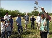 Kelly Kindscher, plant ecologist and associate scientist at the
Kansas Biological Survey, describes some of the plant life found on
the Hall Nature Reserve to a group of about 60 spectators. KU
dedicated the reserve, which is northwest of Lawrence, on Sunday.
