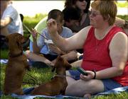 Cheryl Lowrance, Lawrence, feeds treats to her dogs Spritz and
Madison at Art in the Park. Booths featured artists' work for sale
Sunday at South Park.