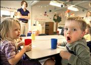 Thomas Allen, right, imitates his tiger animal cracker as Emma
Reynolds watches during snack time at One of a Kind Progressive
Child Care. Facilities like One of a Kind Progressive Child Care
are filled to capacity because of the challenge parents face in
finding good, affordable day care for their children. Success By
Six, a group of local agencies, works to make quality child care
accessible to parents.