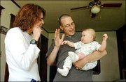 Kester Marsh, center, is graduating Sunday from Kansas University
with a master's degree in deaf education. Marsh can hear, but his
parents, wife and son are deaf, so signing is part of everyday
communication for him. Kester and his wife, Robyn, played with
their daughter, 8-month-old Tymber, trying to teach her some of the
basic signs, Friday afternoon at their home in Eudora.