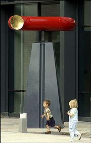 Dorian Vance, 2, left, and Lily Kenn, 3, walk past "Alchemy," a
sculpture installed recently at the Lawrence Arts Center, 940 N.H.
The painted steel sculpture by Willie Ray Parish, La Union, N.M.,
is one of eight works in the Outdoor Downtown Sculpture Exhibition.